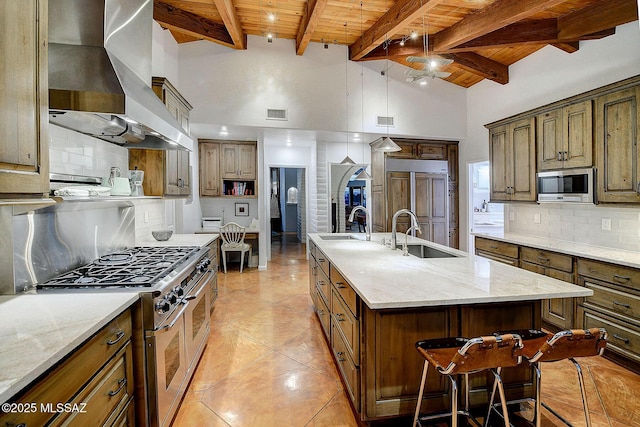 kitchen with sink, high quality appliances, range hood, a kitchen island with sink, and backsplash