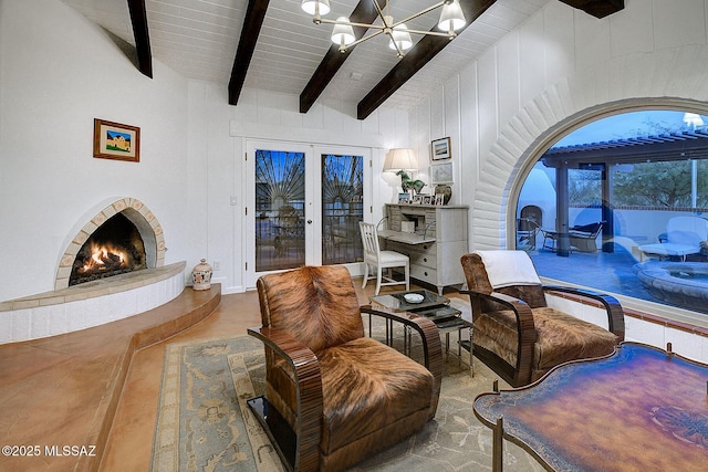 living area with french doors, wood ceiling, lofted ceiling with beams, a notable chandelier, and a tiled fireplace