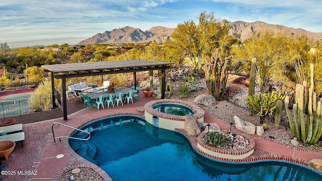 view of swimming pool featuring a patio, a mountain view, an outdoor bar, and an in ground hot tub