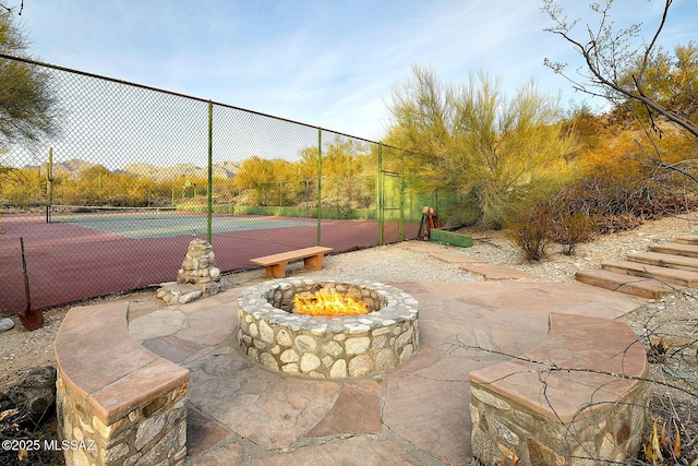 view of tennis court with a fire pit