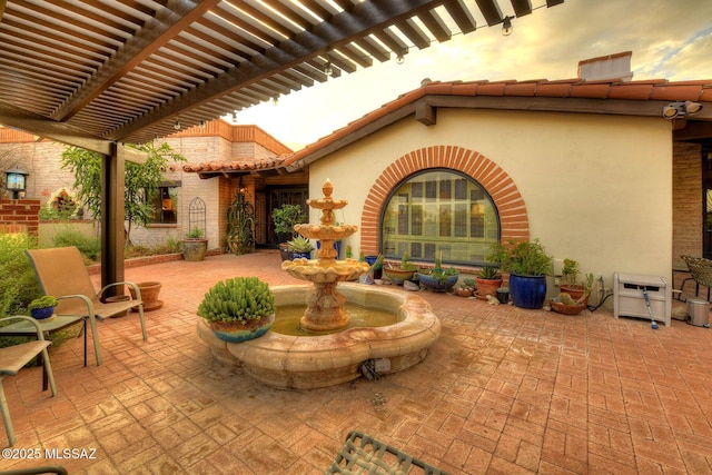 patio terrace at dusk featuring a pergola