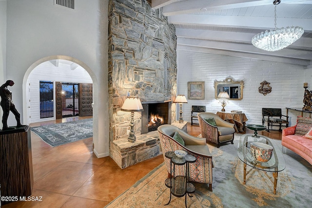 tiled living room with lofted ceiling with beams and a fireplace