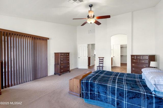 carpeted bedroom featuring a high ceiling and ceiling fan