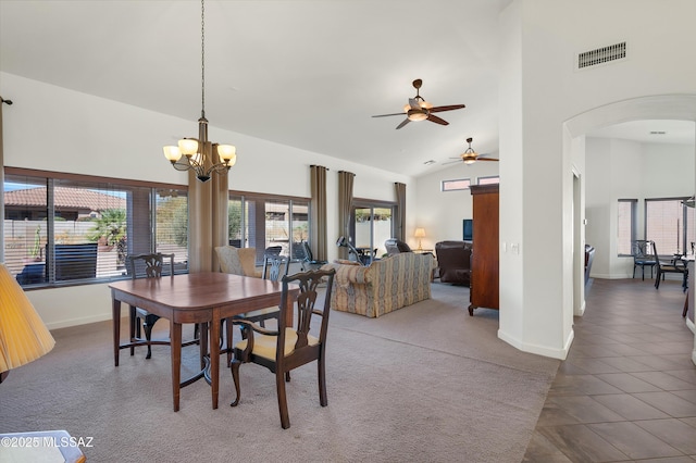 dining space featuring an inviting chandelier, dark tile patterned flooring, and high vaulted ceiling