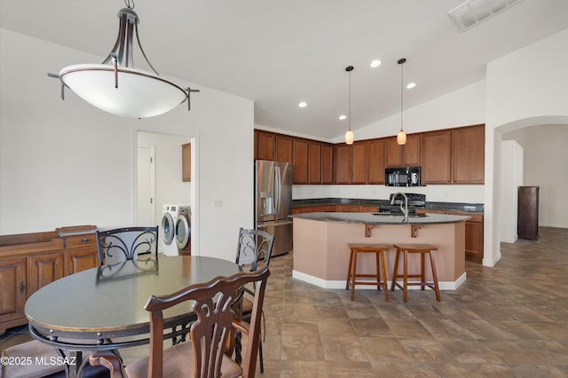 dining space with lofted ceiling, sink, and washer and clothes dryer