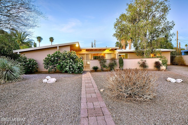 view of front facade with fence private yard and stucco siding