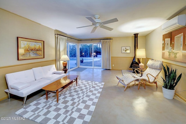 living area featuring ceiling fan, concrete flooring, a wood stove, baseboards, and an AC wall unit