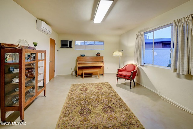 living area with baseboards and a wall mounted air conditioner