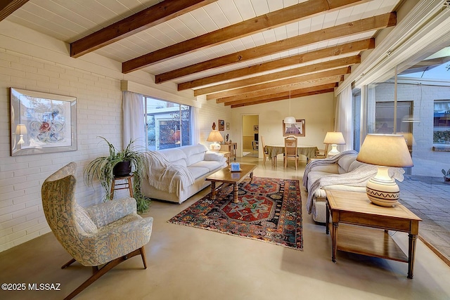 living area featuring brick wall, beam ceiling, and finished concrete flooring