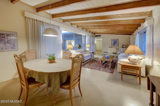 dining space with concrete flooring and beam ceiling
