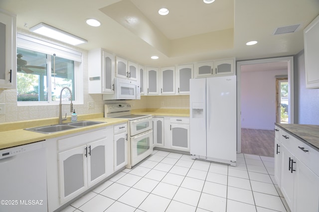 kitchen featuring white cabinetry, sink, and white appliances