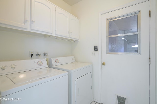 clothes washing area featuring washing machine and dryer and cabinets