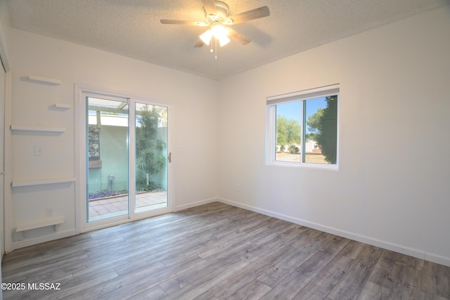 spare room with hardwood / wood-style floors, a textured ceiling, and ceiling fan