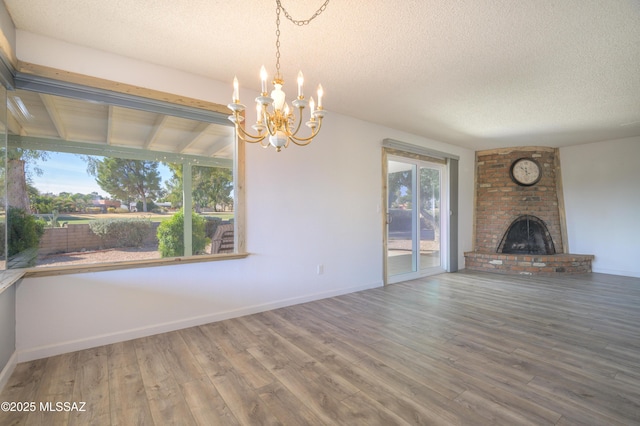 unfurnished living room featuring a fireplace, hardwood / wood-style floors, and a textured ceiling