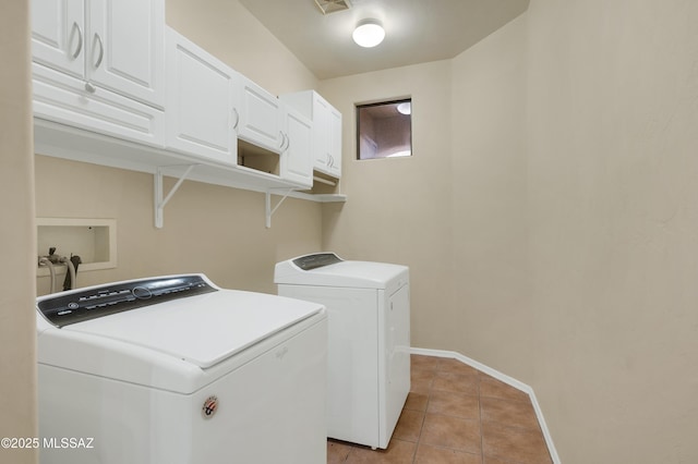 laundry area featuring cabinets, washing machine and dryer, and light tile patterned floors