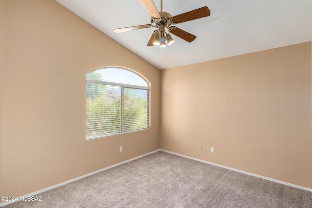 empty room with vaulted ceiling, ceiling fan, and carpet flooring