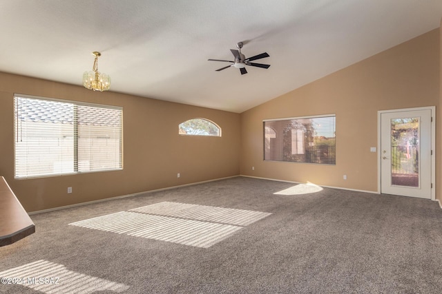 unfurnished living room with ceiling fan with notable chandelier, carpet floors, and high vaulted ceiling