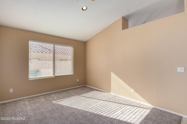 spare room with carpet and lofted ceiling