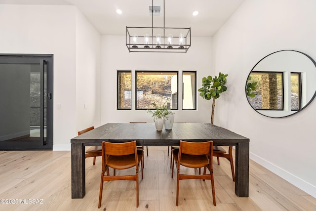 dining area with an inviting chandelier and light hardwood / wood-style floors