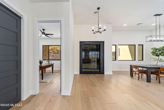 foyer entrance featuring an inviting chandelier and light hardwood / wood-style floors