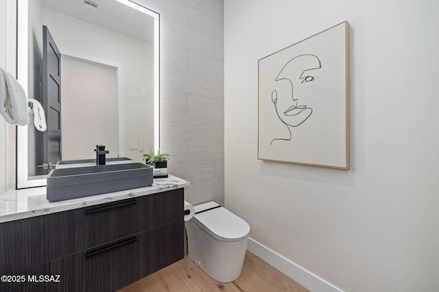 bathroom featuring vanity, toilet, and wood-type flooring