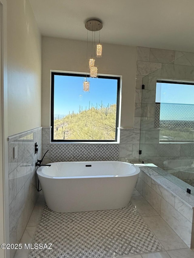 bathroom with plus walk in shower, tile patterned flooring, and tile walls