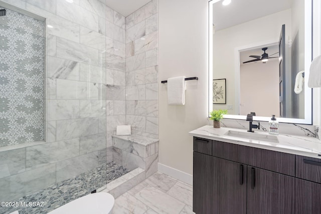 bathroom with vanity, toilet, ceiling fan, and a tile shower