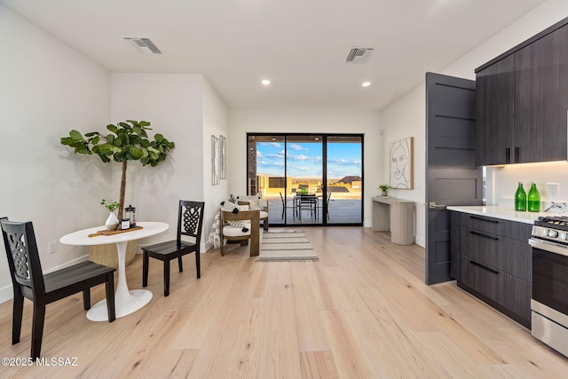 kitchen featuring dark brown cabinets, light hardwood / wood-style flooring, and gas stove