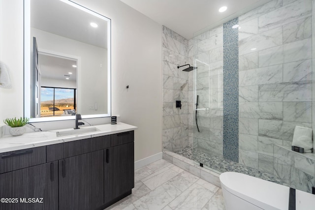 bathroom with tiled shower, vanity, and toilet