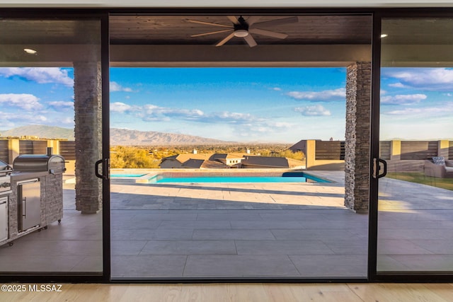 doorway to outside with a mountain view, hardwood / wood-style flooring, and a healthy amount of sunlight