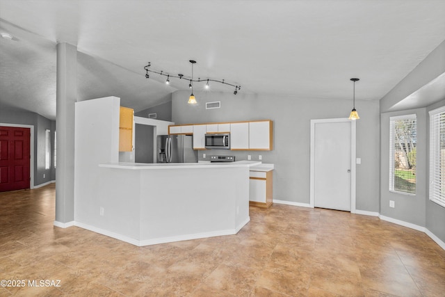 kitchen with lofted ceiling, appliances with stainless steel finishes, hanging light fixtures, and white cabinets