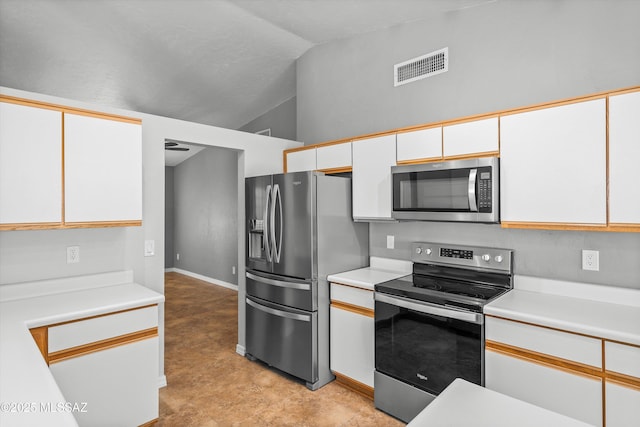 kitchen with vaulted ceiling, white cabinets, and appliances with stainless steel finishes