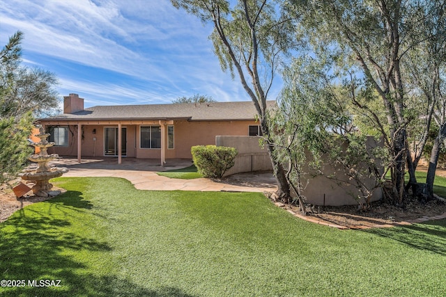 back of house with a patio area and a lawn