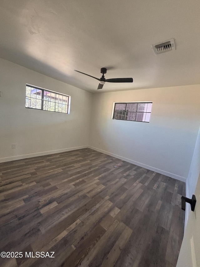 spare room with ceiling fan and dark wood-type flooring