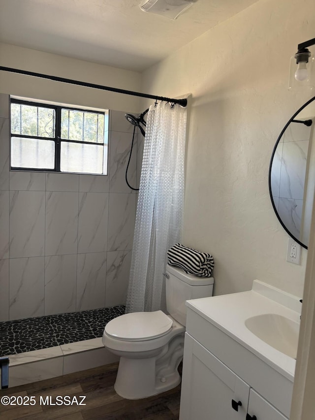 bathroom featuring toilet, hardwood / wood-style flooring, vanity, and curtained shower