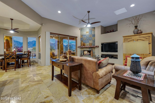 living room with a fireplace and ceiling fan