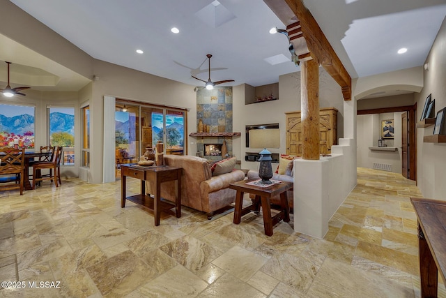 living room with ceiling fan and a large fireplace