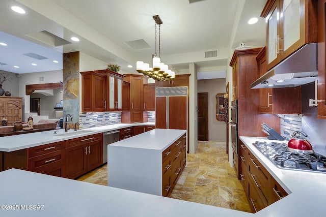 kitchen featuring a kitchen island, sink, backsplash, hanging light fixtures, and stainless steel appliances