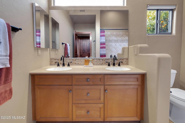 bathroom featuring a shower with curtain, vanity, backsplash, and toilet