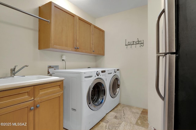 washroom with cabinets, sink, and washing machine and clothes dryer