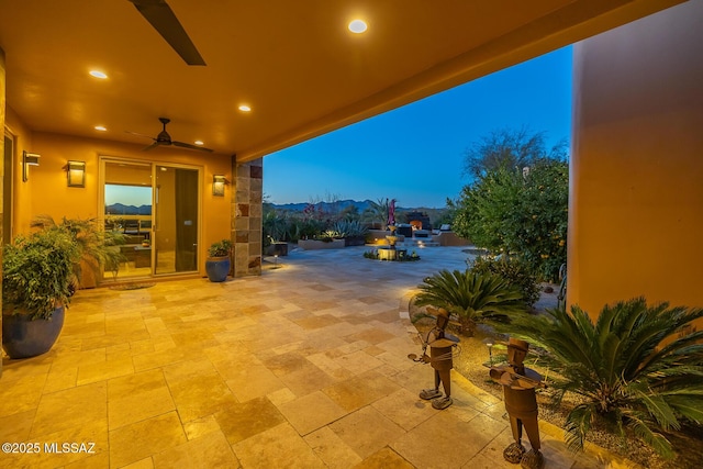 patio terrace at dusk featuring ceiling fan