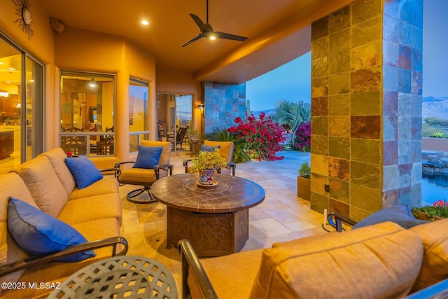 patio terrace at dusk featuring an outdoor living space with a fire pit and ceiling fan