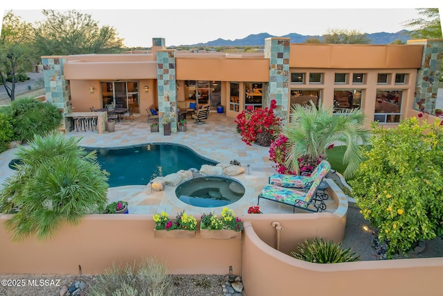 view of swimming pool with a mountain view, a patio, and an in ground hot tub