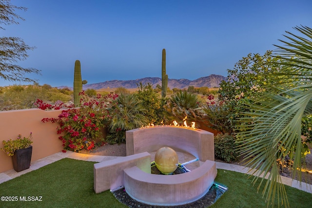 yard at dusk featuring a mountain view