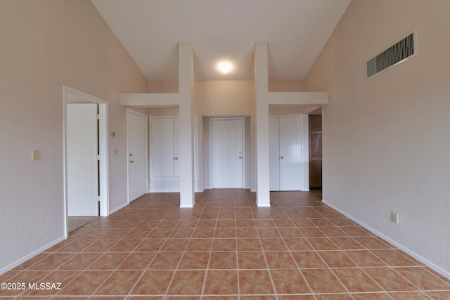 unfurnished bedroom with light tile patterned floors, vaulted ceiling, and visible vents