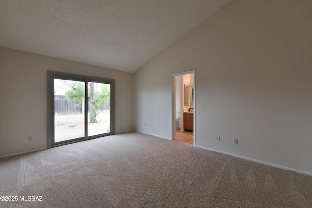 empty room featuring light carpet, baseboards, and lofted ceiling