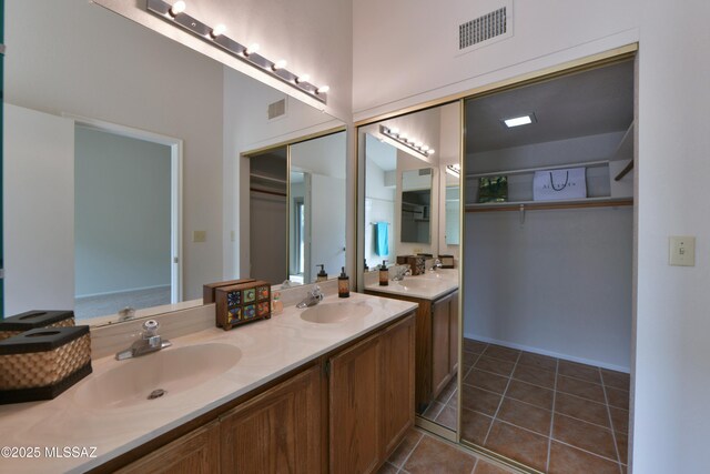 full bath with double vanity, a sink, tile patterned flooring, and visible vents