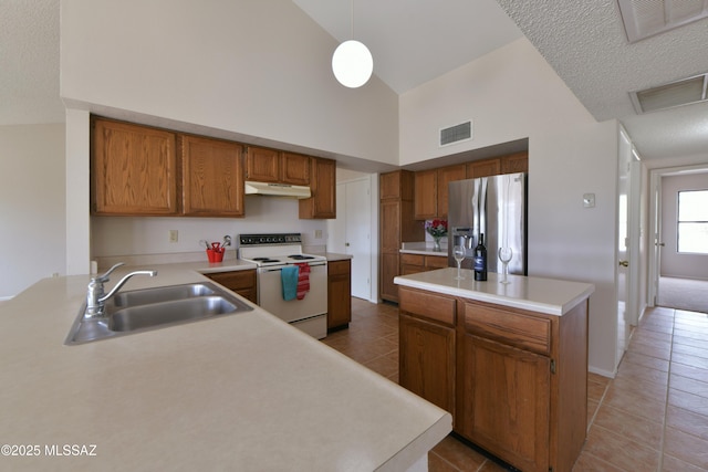 kitchen featuring stainless steel fridge with ice dispenser, electric range, visible vents, high vaulted ceiling, and a sink