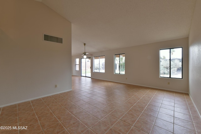 spare room with visible vents, ceiling fan, vaulted ceiling, and light tile patterned flooring