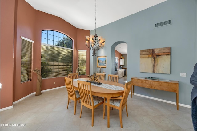 dining space featuring a chandelier and high vaulted ceiling